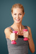 © sepy - Fitness. Portrait of an attractive blond woman working out with dumbbell weights, toning her biceps while standing against isolated background.