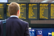 Commuter Checking Digital Timetables At A Train Station