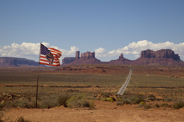 The American flag with Monument Valley in the background