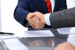 © rogerphoto - Two business man shaking hands to each other above signed contract