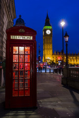 Wall Mural - Famous English red telephone boxes with Big Ben in London at nig