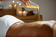 © Cookie Studio - Honey pouring on girl's naked back in spa salon.