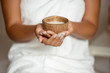 © Cookie Studio - Close up of girl holding coconut in spa salon.