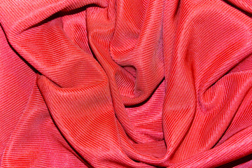 Texture, background of bright red draped silk fabric corded