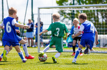 Football Soccer Match For Children. Boys Playing Football Game On A School Tournament. Dynamic, Action Picture Of Kids Competition During Playing Football. Sport Background Image.