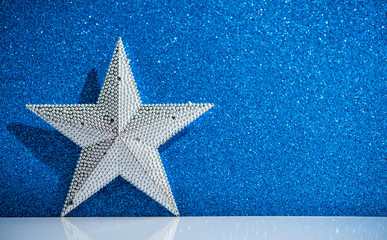 Wall Mural - silver star on abstract blue glitter holiday background. winter xmas holidays. christmas. space for 