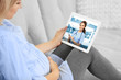 © Africa Studio - Pregnant woman video chatting with doctor on tablet. Professional medical online consultation concept.