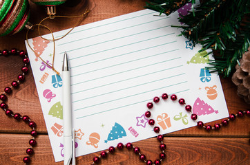 Beautiful blank sheet for letters to Santa for Christmas. Paper and pen next to Christmas decorations