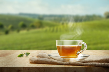 Wall Mural - Warm cup of tea and tea leaf and sack on the wooden table and th