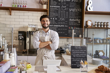 Wall Mural - Business owner at the counter of coffee shop, arms crossed