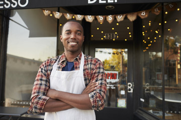 Black male business owner standing outside coffee shop