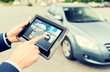 © Syda Productions - close up of hands with news on tablet pc and car