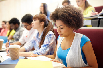 Poster - group of students with coffee writing on lecture