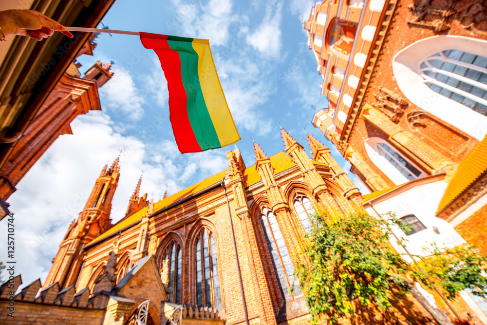 Obraz na płótnie View on the beautiful gothic saint Anna and Francis of Assisi churches eith lithuanian flag in the old town of Vilnius city, Lithuania. w salonie