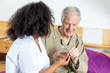© jovannig - Elder man taking pills from nurse in hospital bed
