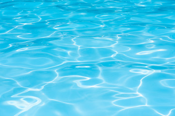 blue water in swimming pool witn sun reflection