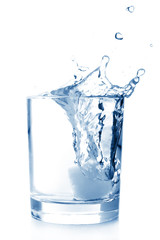 Wall Mural - Ice in glass of water with splash on white background .