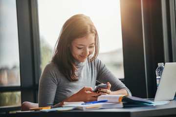 Asian girl using mobile phone at library