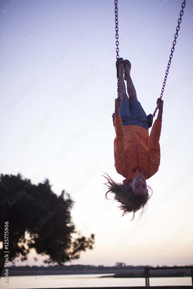 Adult Woman Swinging Upside Down On A Swing At A Park In San