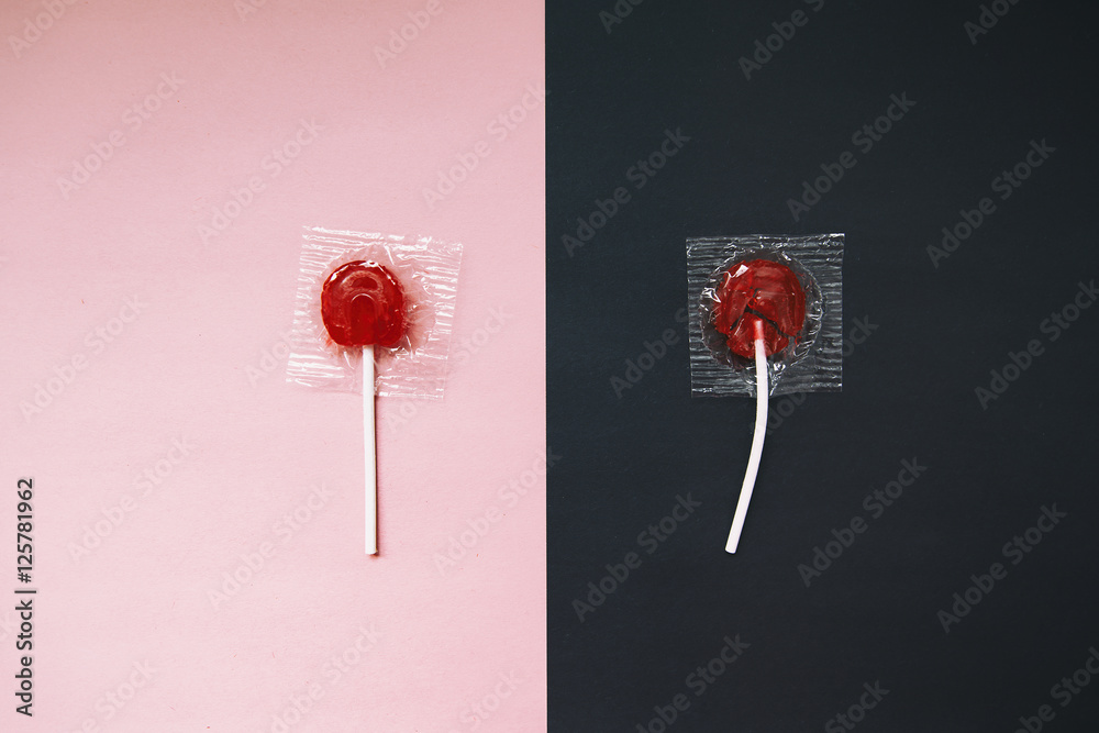 lollipops on pink and black background. the contrast between the whole and broken candy lollipop. the concept of contrast. before and after. top view - obrazy, fototapety, plakaty 