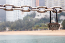 Padlock With Text Love Hanging On A Chain On The Beach