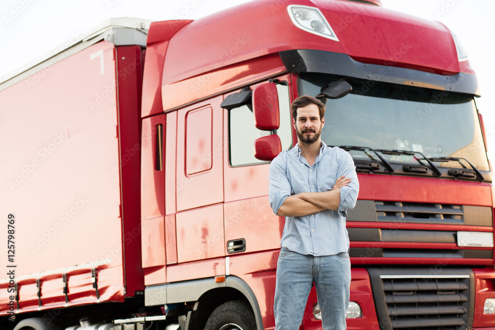 masculine truck driver in jeans with his truck behind - obrazy, fototapety, plakaty 