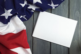 Fototapeta  - United States of America flag with empty space to write your text on sheet of paper on wooden background.