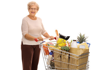 Wall Mural - Cheerful mature lady with shopping cart