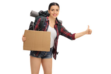 Poster - Female hiker hitchhiking and holding blank cardboard sign