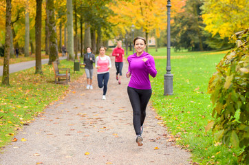 Four young woman out running together in a park