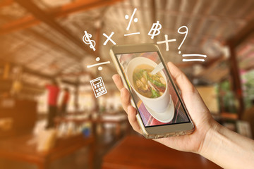 Wall Mural - Woman Hand holding smartphone with Geometry symbol in the restaurant for order some food