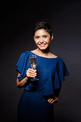 Beautiful brunette girl in evening dress smiling, holding champaign glass.