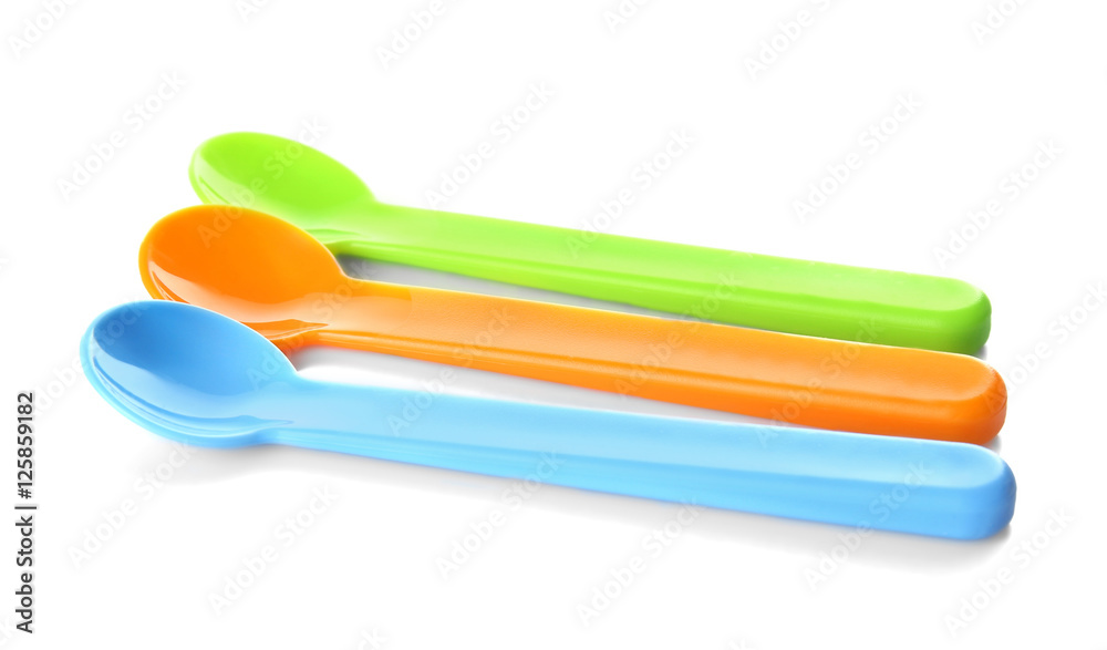 Colorful plastic spoons for child on white background