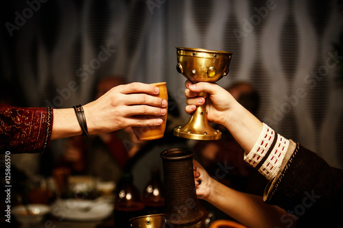 Cuadros en Lienzo people clink cups on a medieval feast.