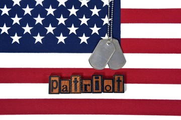 Wall Mural - word patriot in vintage wooden letterpress type and dog tags on American flag