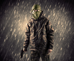 Armed terrorist man with mask on rainy background