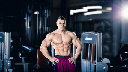 Male bodybuilder, fitness model trains in the gym