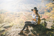 © yossarian6 - Young hipster woman sitting at viewpoint and looking at map for direction