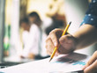 © jakkaje8082 - Closeup hand holding pencil and paperwork sheet for business successful teamwork with blurred focus backgrounds