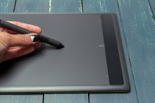 Hand of graphic designer working with stilus and tablet