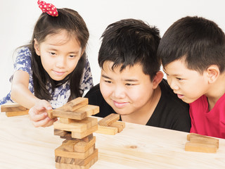 Wall Mural - Children is playing a wood blocks tower game for practicing their physical and mental skill