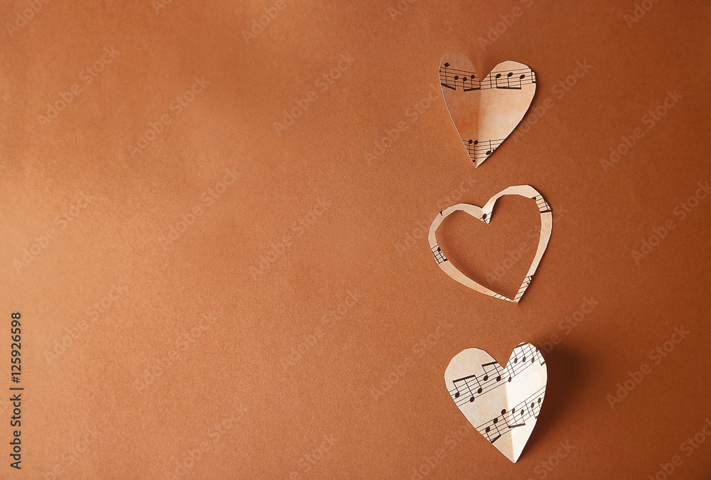 Paper hearts with music notes on brown background