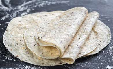 Poster - Stack of tortillas on a black surface