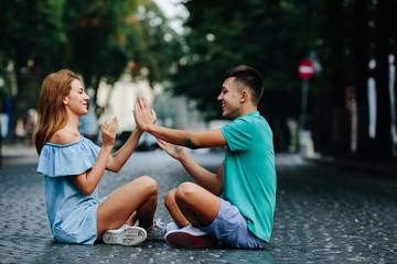 Wall Mural - couple sitting on pavement square