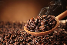Wooden Spoon With Roasted Coffee Beans On Blurred Background
