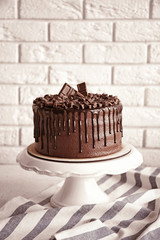 Wall Mural - Tasty chocolate cake on brick wall background