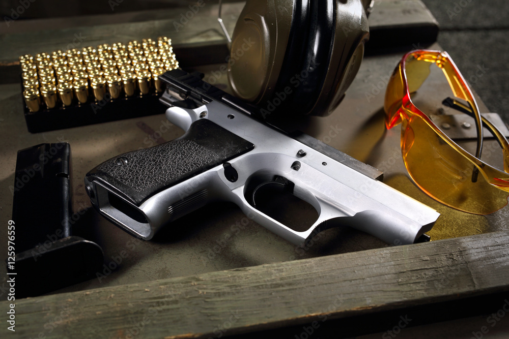 Pistolet CZ Shadow. Pistolet Cz, naboje i słuchawki ochraniające uszy, sprzęt strzelecki - obrazy, fototapety, plakaty 