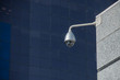 Modern security camera over office building background