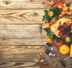 Wall Mural - Holiday dinner on the table. Chicken and vegetables and tablewar