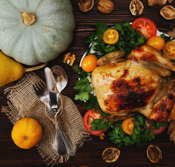 Wall Mural - Holiday dinner on the table. Chicken and vegetables and tablewar